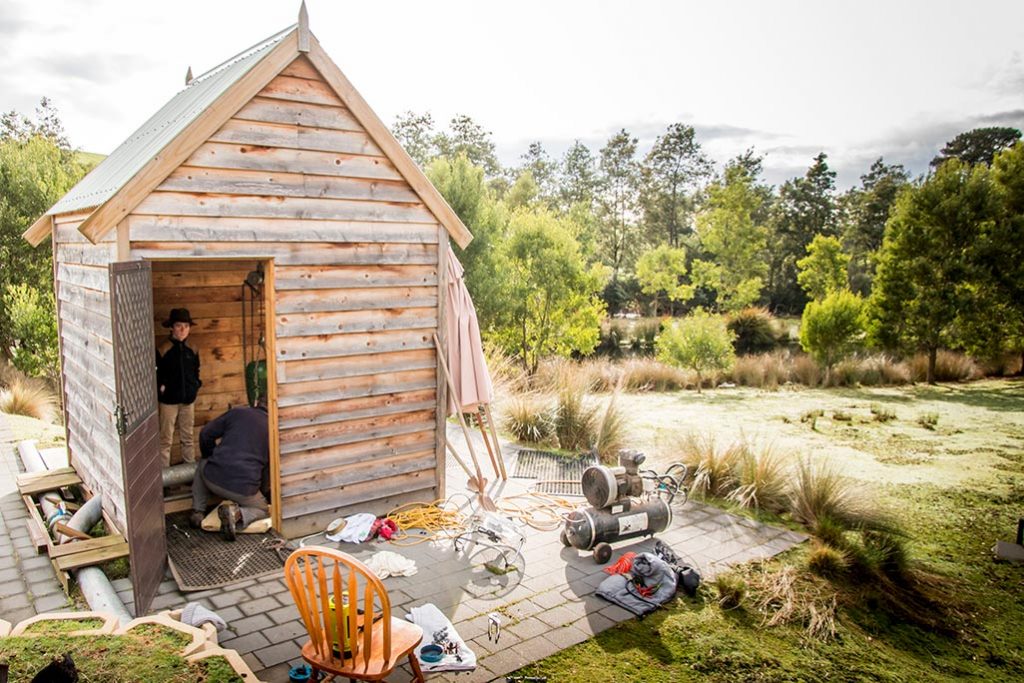 James and Graham seen through the open door of the small timber micro-hydro shed.
