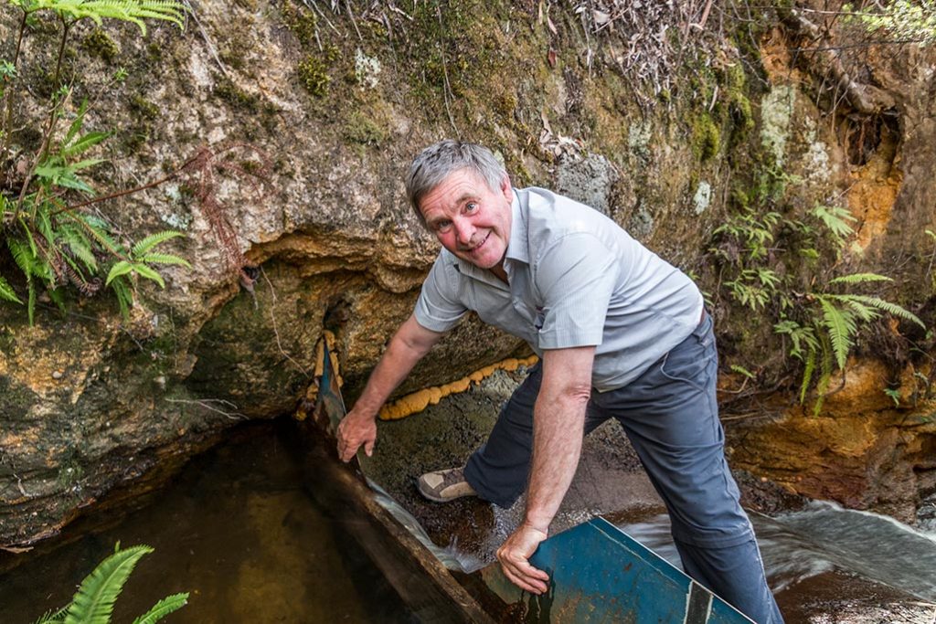 Graham standing below the V-notch weir measuring the water flow into the creek