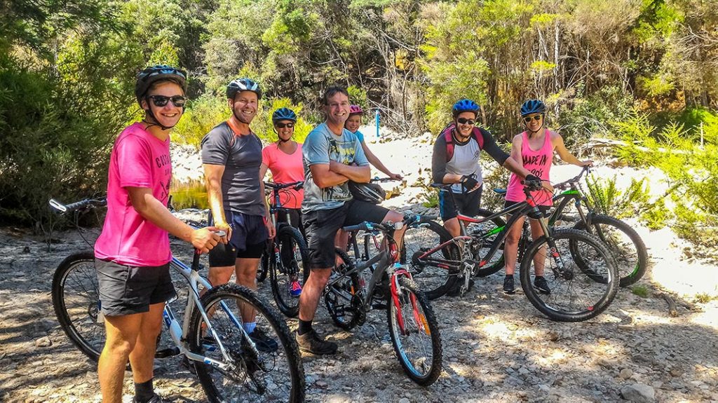 A group of happy young people with their mountain bikes posing for the camera at Blue Derby