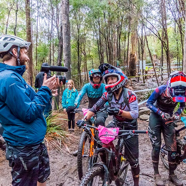 Young male interviewer enjoying a moment with a female competitor during the World Enduro Series 2018