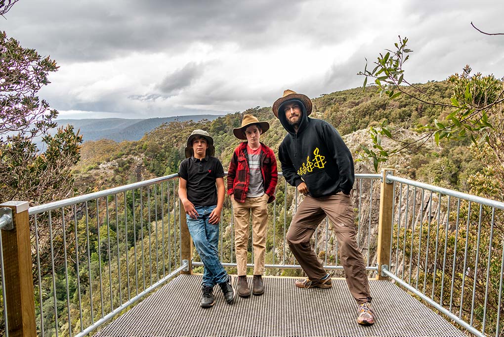 Two teenagers and a man on the Ralphs Falls Lookout above the falls in North East Tasmania
