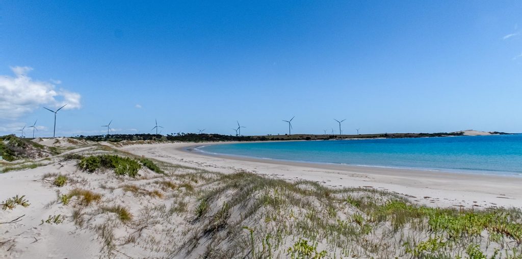 The wind turbines dominate the skyline beyond the sweeping beach of Little Musselroe Bay in North East Tasmania