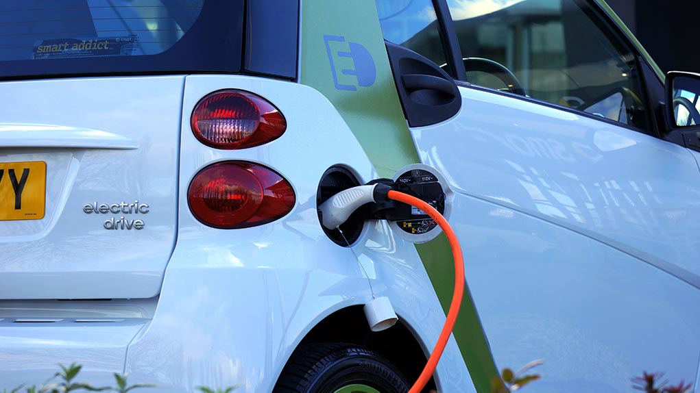 White electric vehicle is being recharged as the eco-friendly travel option