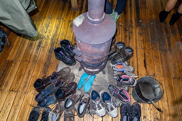 Shoes drying around the coal fire in the Lake Vera Hut