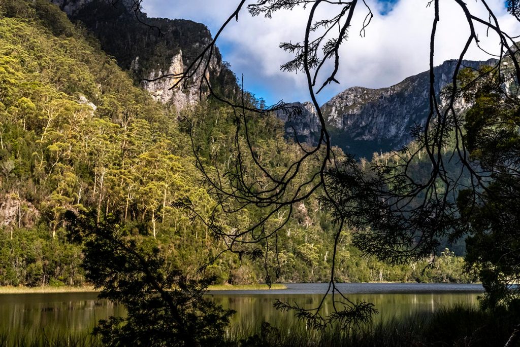The wild landscape is reflected in the still water of Lake Vera