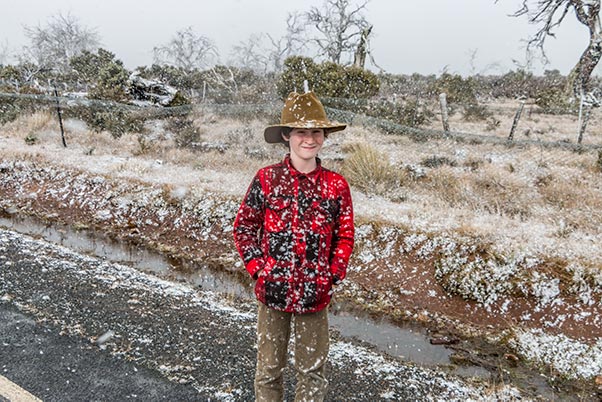 James standing on the side of the road with snow falling in the Tasmanian highlands