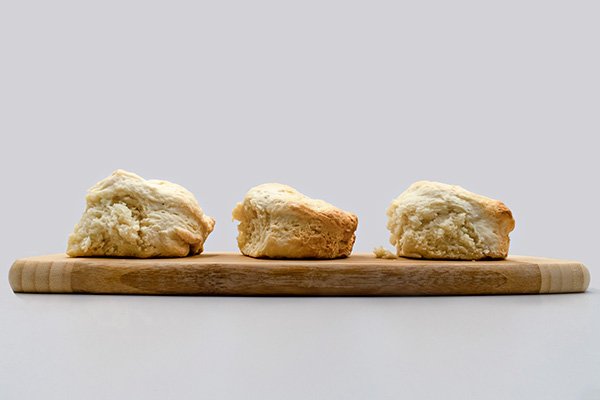 Three scones sitting on a wooden board.