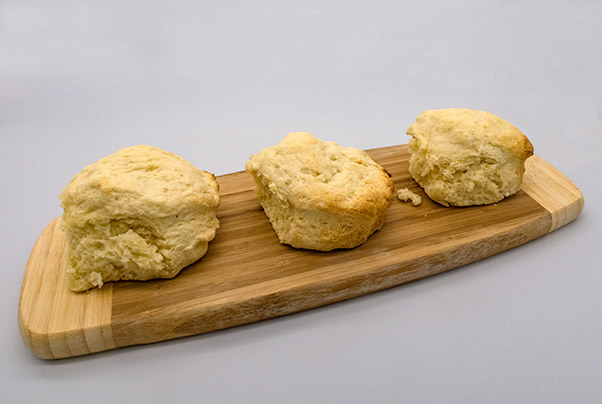 Three scones sitting on a wooden board