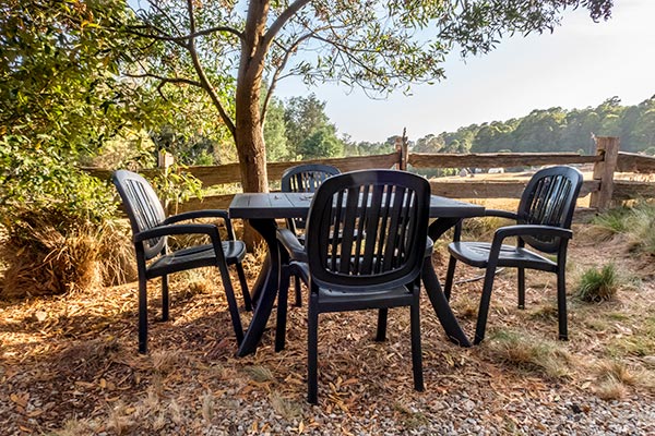 Garden furniture outside Ah Ping cottage looks out over the alpaca paddock towards the Ringarooma River.