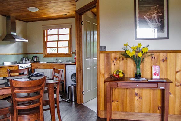Interior of Ah Ping cottage shows the kitchen, dining area and door leading to the bathroom.