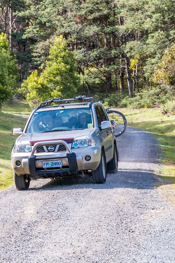Car carrying mountain bikes driving on the road at Tin Dragon Trail Cottages