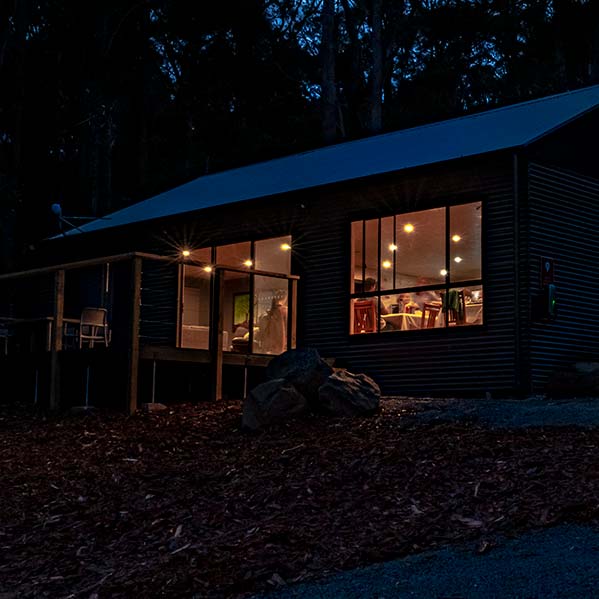 An evening view of the Barn with inside lights glowing.