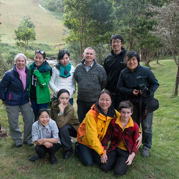 Film crew from World Traveler with their interpreter posing near the Ringarooma River at Tin Dragon Cottages.