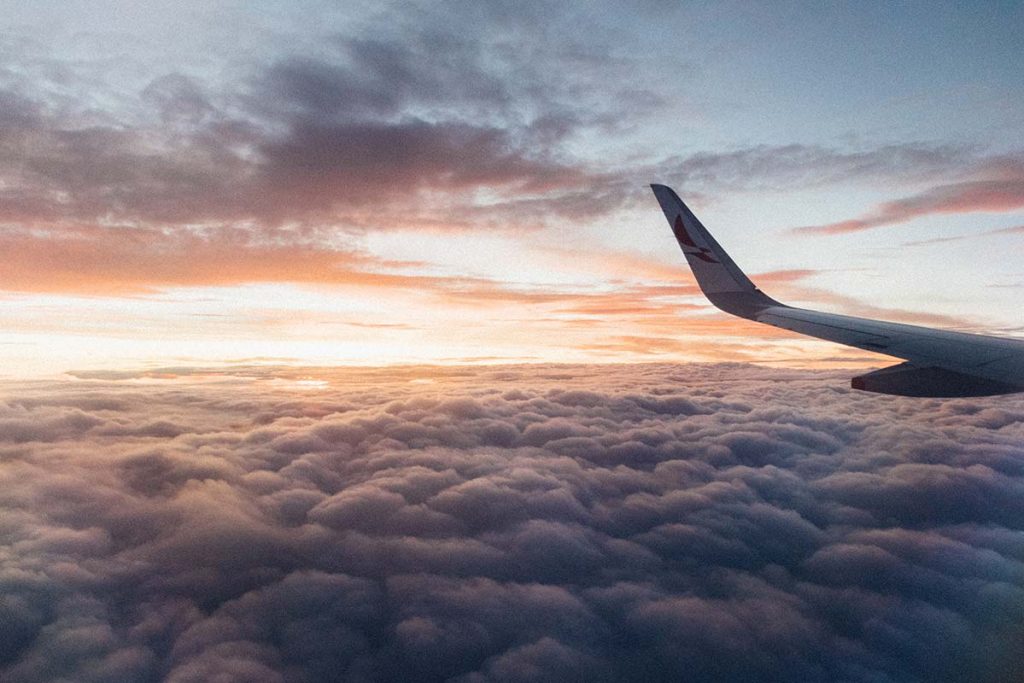 White airliner wing on top of a sea of clouds