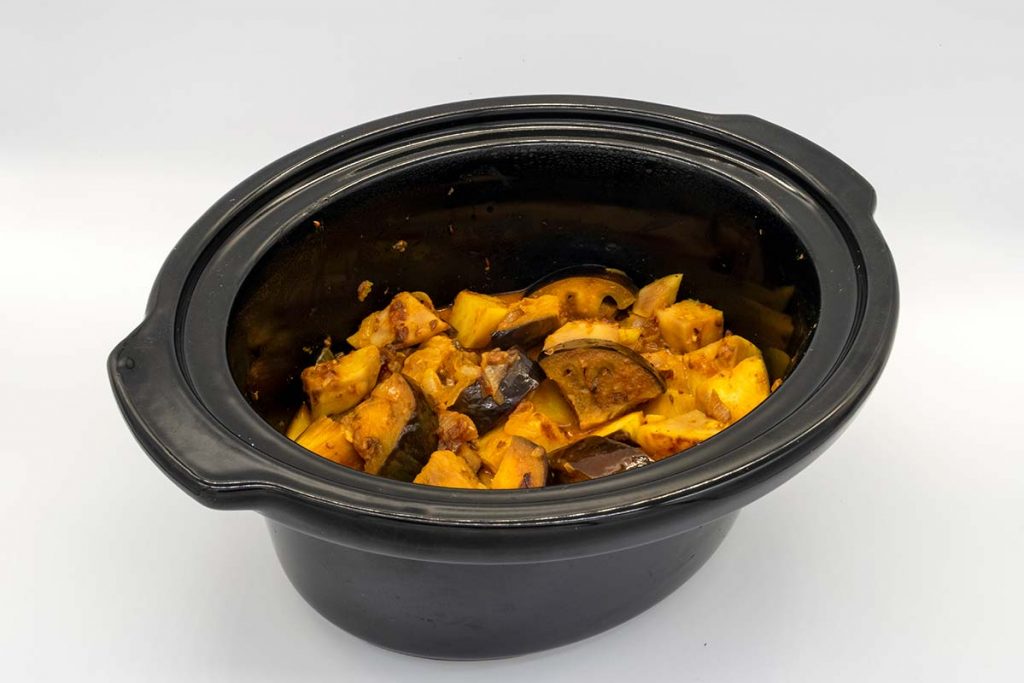 brinjal curry recipe being cooked in a ceramic crock pot
