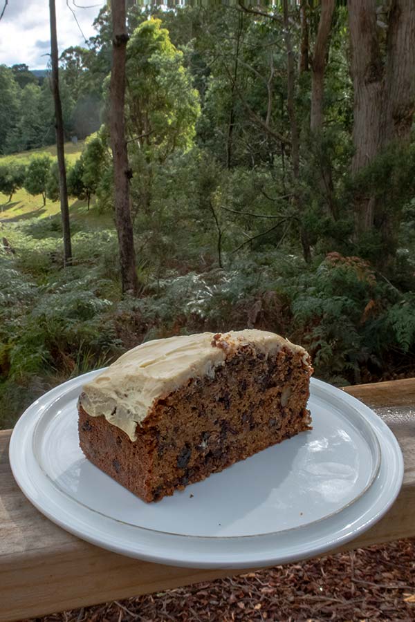 This iced carrot cake sitting on an outdoor table overlooking the garden and mountains is the result of my best ever carrot cake recipe.