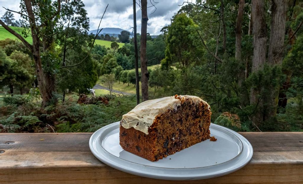 This is my best ever carrot cake placed on a balcony railing looking out towards the mountains in the distance.