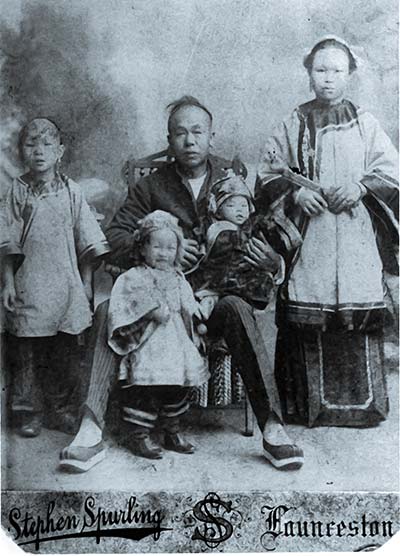 Ah Moy family wearing traditional dress for studio photo, late 1800s.