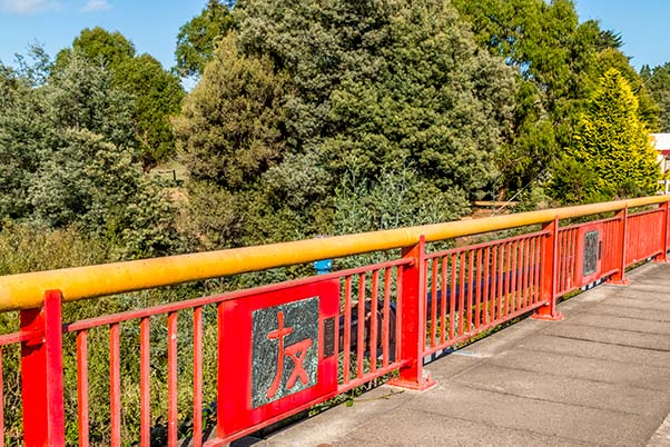 The red and gold Branxholm Bridge has Chinese calligraphy inspired icons to commemorate the towns Chinese history.
