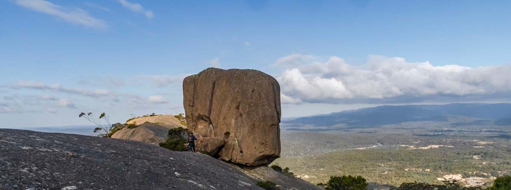 Cube rock sitting on Windy Ridge looks out over the mountains to the sea