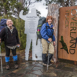 Graham and Christine standing in front of the iconic Overland Track sign at Lake St Clair in Tasmania