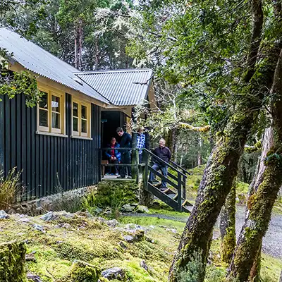 This is a view of the front of one of the Walkheim Cottages in the Cradle Mountain National Park. Graham and James are standing on the small front porch.