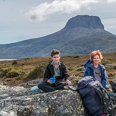 James and Christine sitting on a granite rock with Lake Will and Barn Bluff in the background.