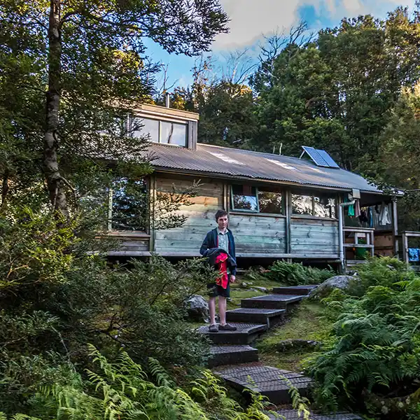 James is standing on the steps below the hut a Windermere.