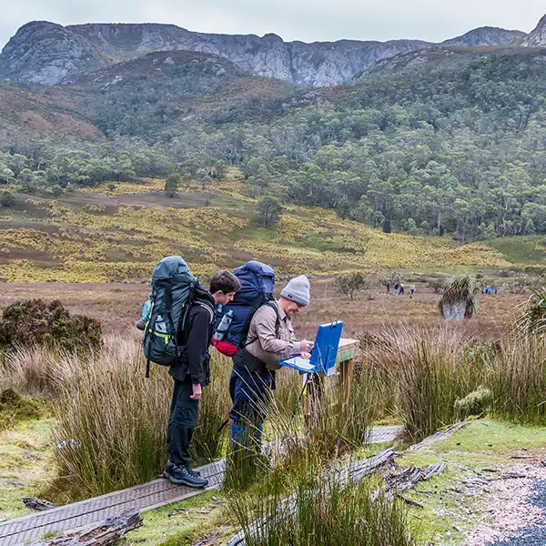 James and Graham with full backpacks signing the book at the start of the Overland Track