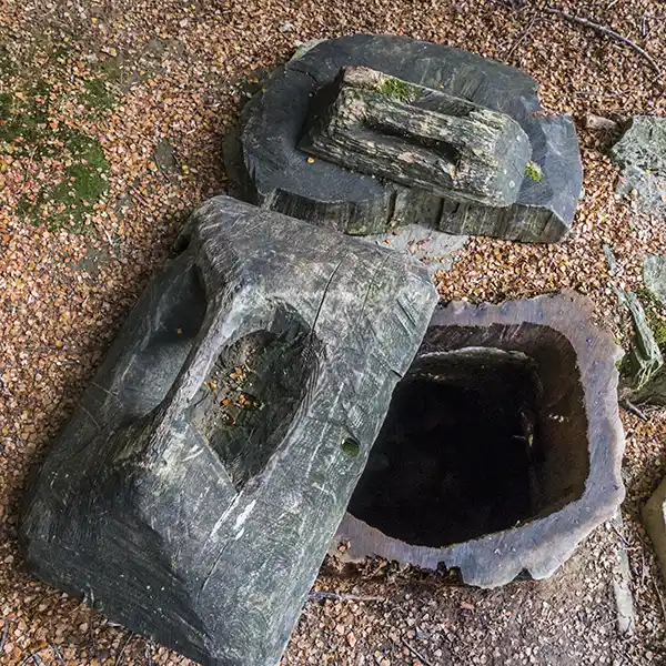 This hole in the ground toilet features a hollow log entrance and a timber cover.