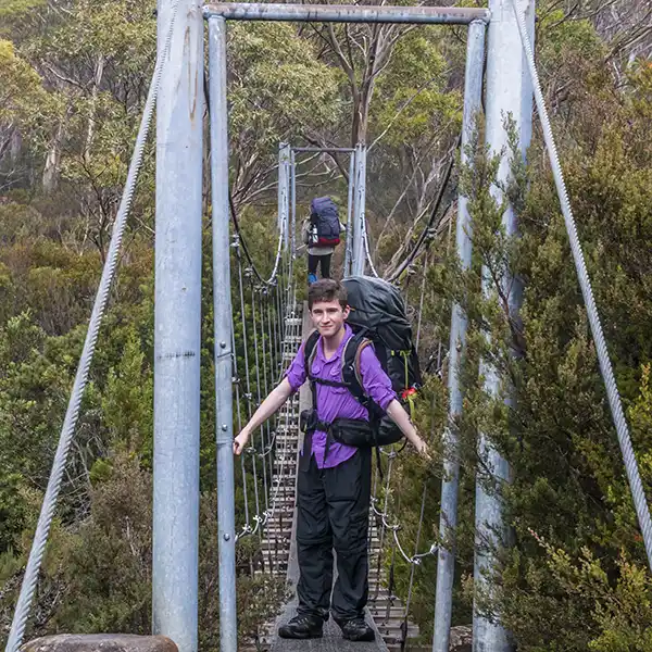 James is facing the camera as Graham reaches the far side of the swing bridge.