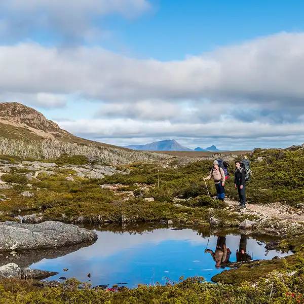 James and Graham with their images clearly reflected in a small tarn - Cradle Mountain plateau, Overland Track.