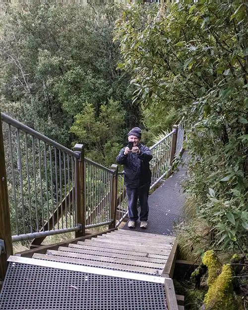 Graham is standing on the well-formed staircase leading down to the waterfall look out.