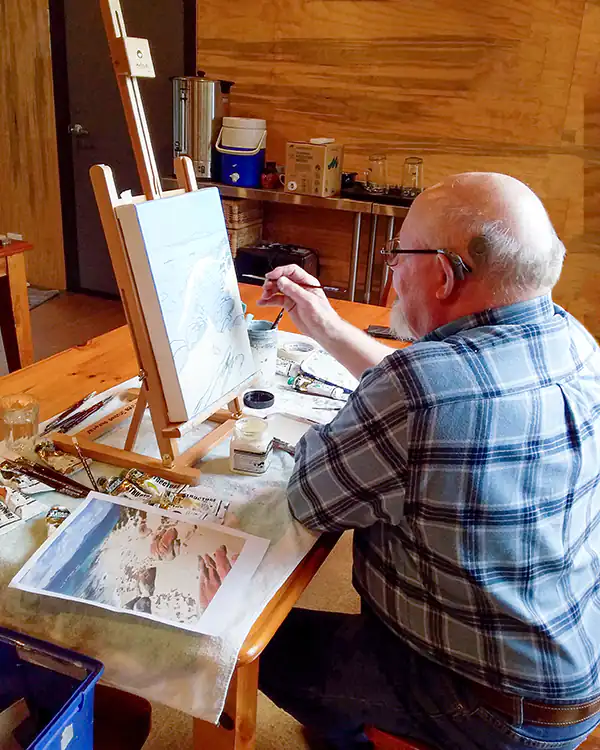 Jphn Gibb sitting, working on an acrylic painting