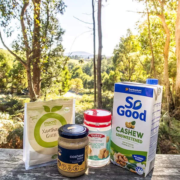 The four ingredients for the vegan blueberry gelato are sitting on awooden verandah rail.