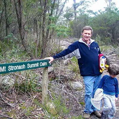 Graham and James in 2005 standing next to the Mount Stronach Summit guide sign. James is almost three years old and is carrying his favourite blanket.