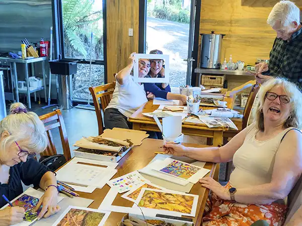 A happy group of artists sharing a laugh during a workshop.