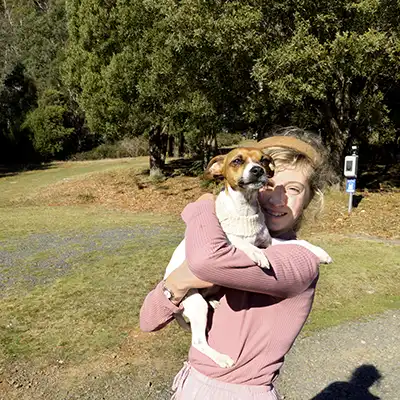 A small girl is higging a mini fox terrier dog.