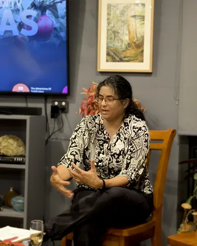 Dr Tanya Scharaschkin sitting on a chair talking to the nature journaling participants.