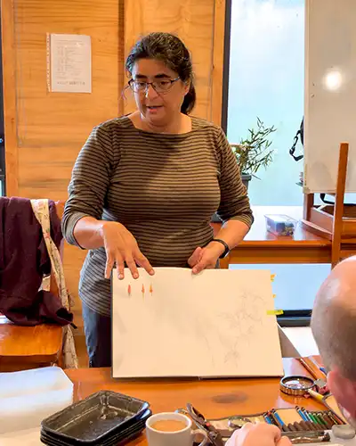 Dr Tanya Scharaschkin is holding a large sketch book, while talking to the retreat participants.