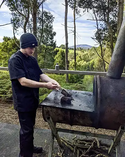 James cooking on an outside wood-fires BBQ