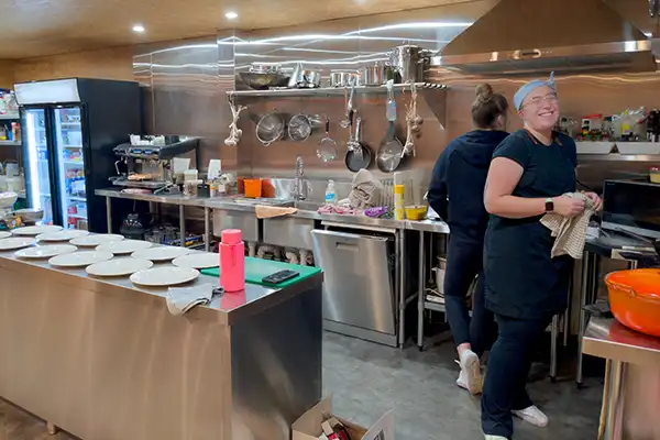 Chef Sarah has plates arranged on the servery, ready to plate the main course.