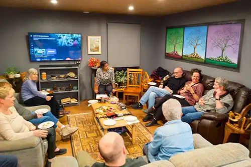 Guests seated in the lounge area of the barn, enjoying a wine and selection of Tasmanian cold meats, cheeses, biscuits and dips.