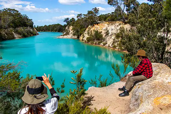 A woman is taking a photo of the Little Blue lake on the Tasmanian nature-based tour