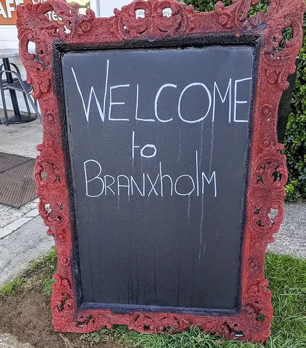 A blackboard sign out on the footpath says Welcome to Branxholm