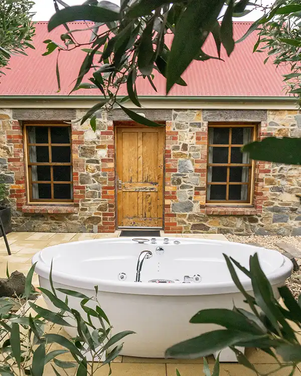 A massage spa bath in front of the Chintock stone cottage at Tin Dragon Cottage near Derby in Tasmania