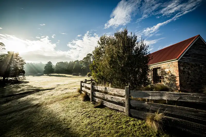 A frosty sunrise shining on the stone cottage at Tin Dragon Cottages in North East Tasmania