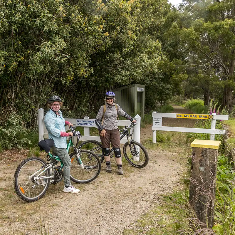 Two older women with bikes at the start of the North East Rail Trail